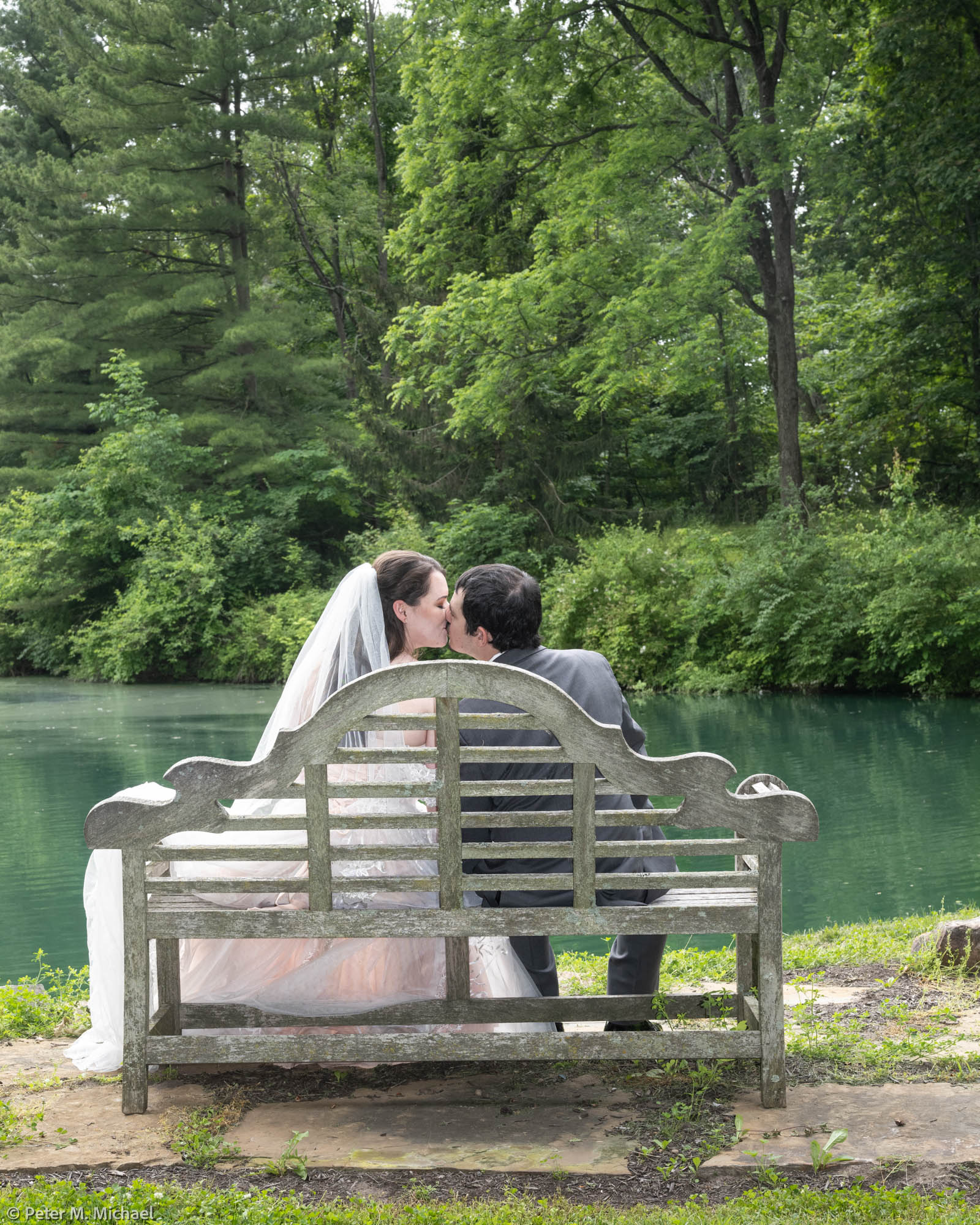 couple kissing on bench outdoors