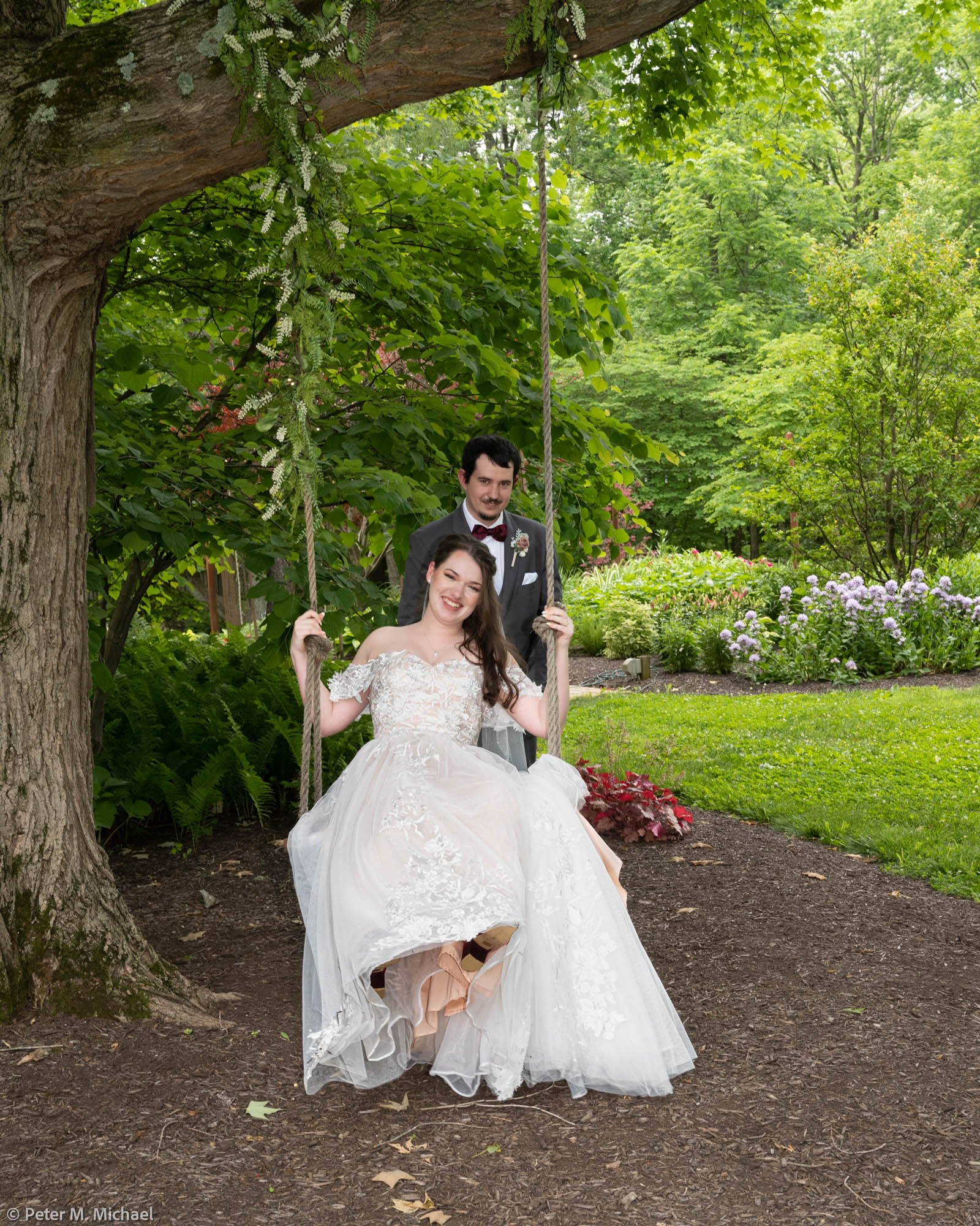 groom pushing bride on swing