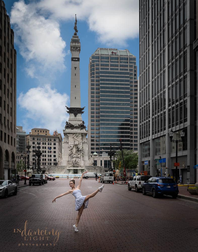 A ballerina dances in the street in front of the Indianapolis circle monument