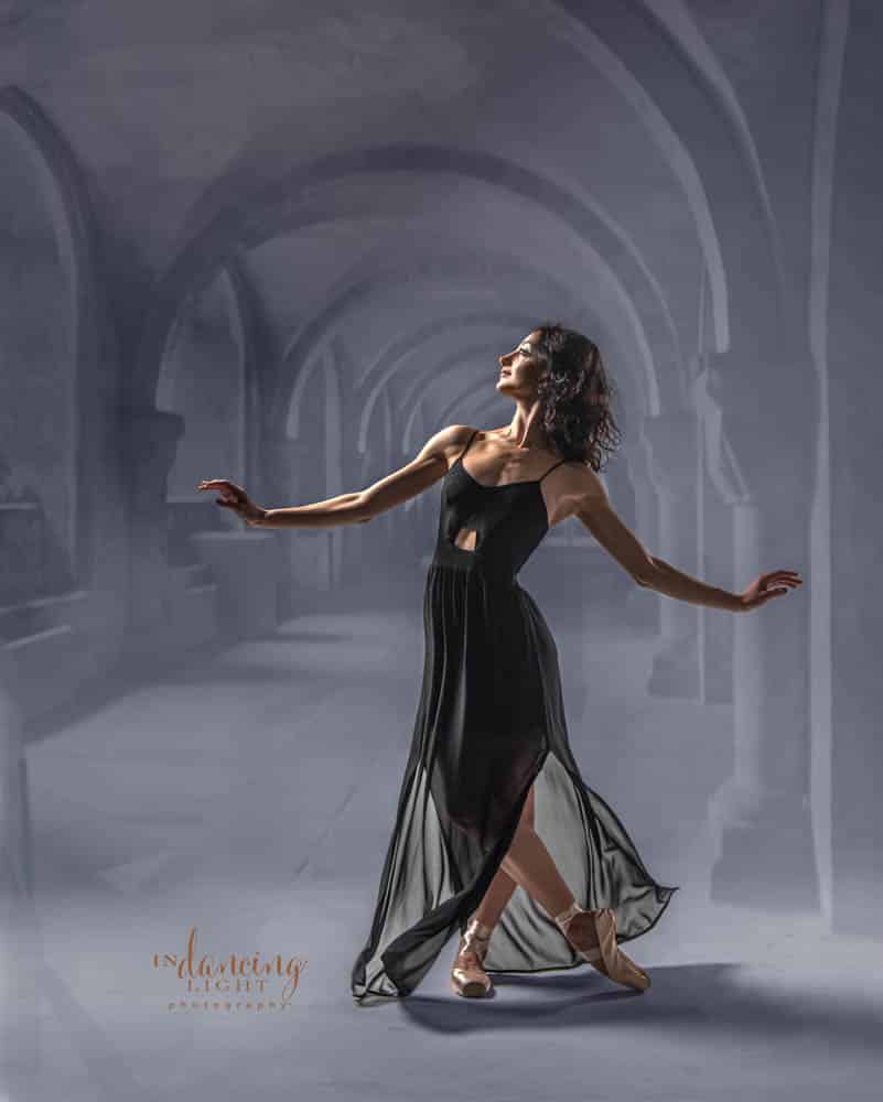 Ballerina dances in an arched hallway