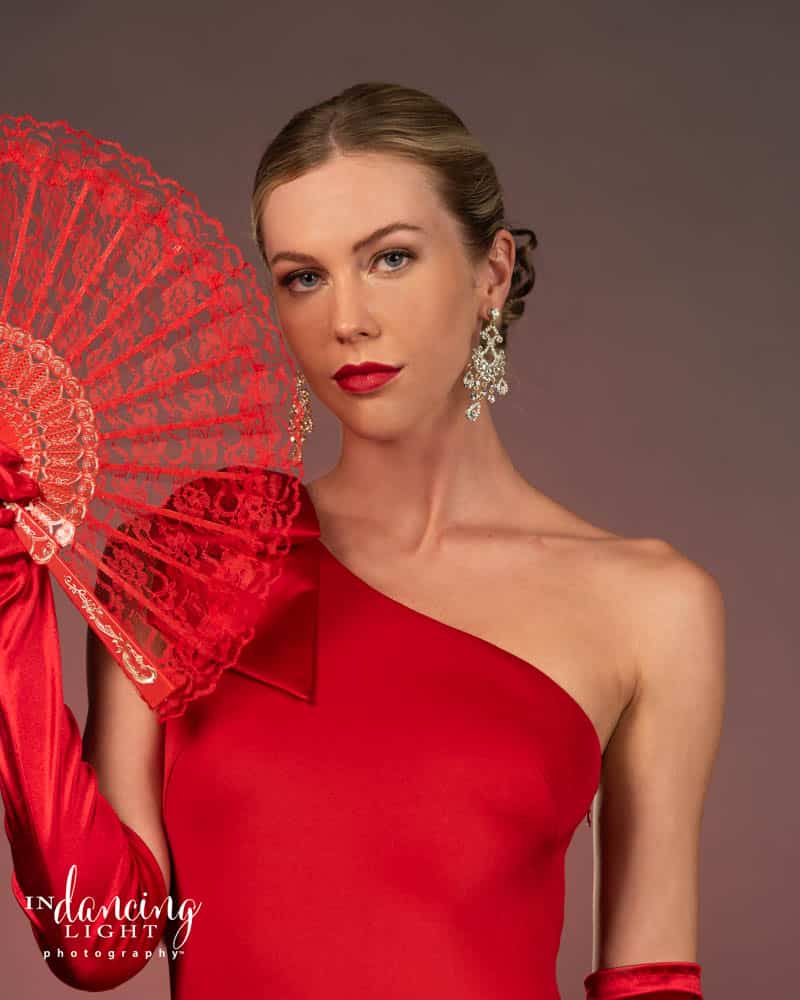 Glamor portrait of a woman in a red dress and oriental fan