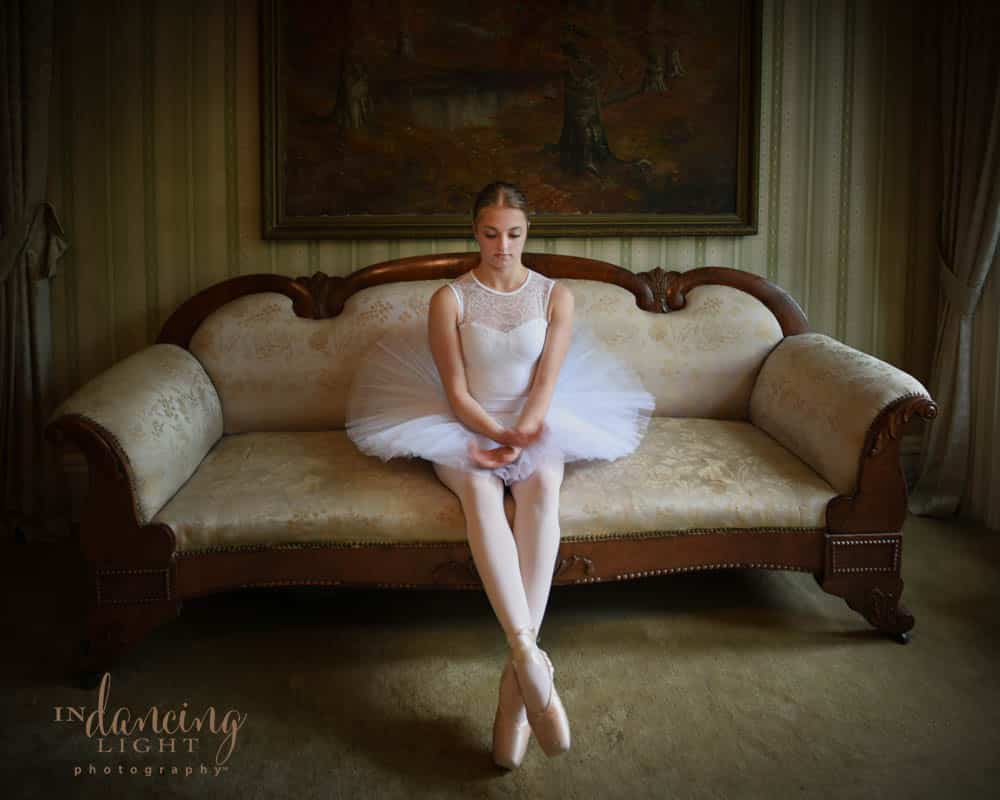 Ballet dancer with tutu sits on a sofa