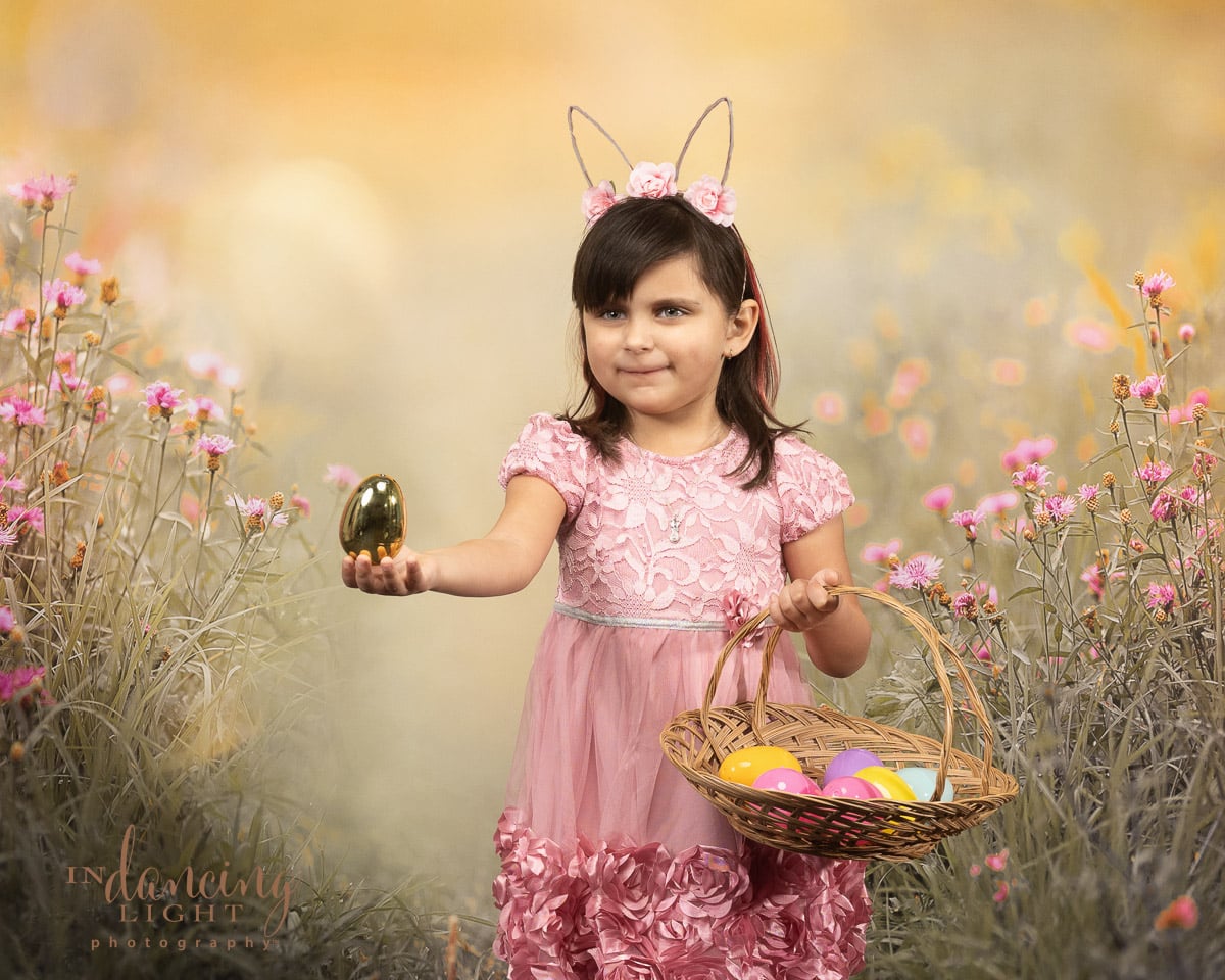 Portrait of a young girl holding an egg and an Easter basket