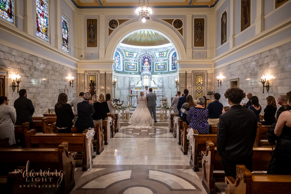 Wedding couple during the ceremony in SS. Peter & Paul Cathedral chapel in Indianapolis