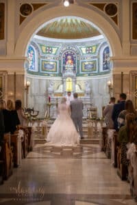 Wedding couple during the ceremony in SS. Peter & Paul Cathedral chapel in Indianapolis