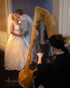 A harpist plays while the wedding couple kiss