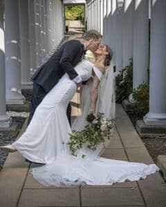 Bride and groom dip under a pergola